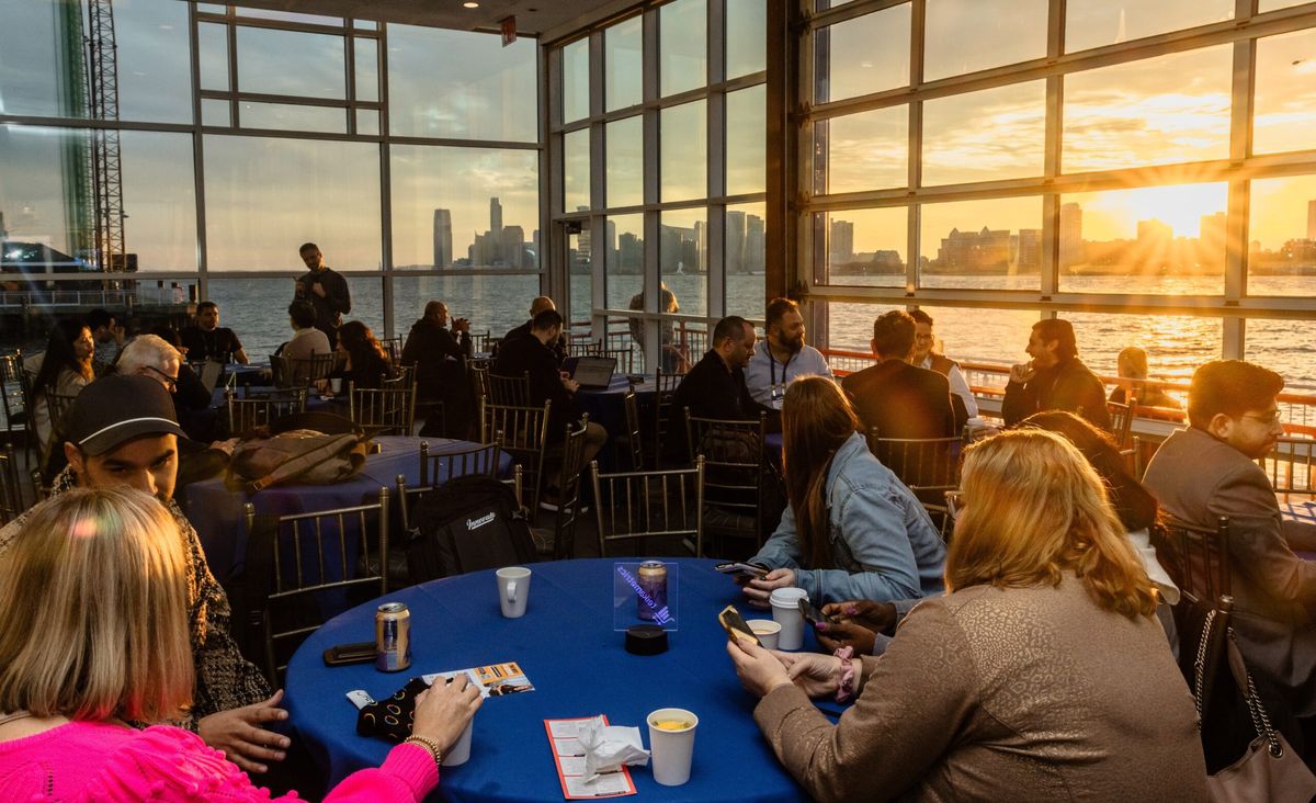 Attendees in conversation at Innovate beside the Hudson River